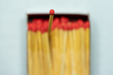 Set of several defocused red-headed matchsticks with one red-headed matchstick in evidence.