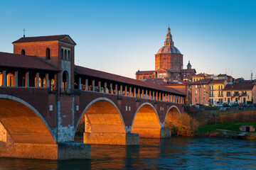 Fototapeta na wymiar Panorama of covered bridge and Pavia cathedral at sunset