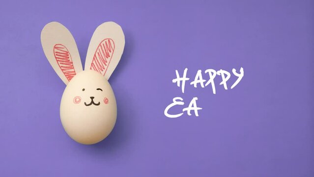 4K animated video. Top view chicken egg with cute smile bunny face and rabbit ears on purple table. Trendy animation with handwritten white text. Happy Easter gift. Farm food. Type. Egg hunt. Flat lay