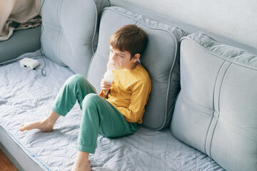 little boy sits with an inhalation mask during cough and bronchitis. Treatment with an inhaler at home - obrazy, fototapety, plakaty