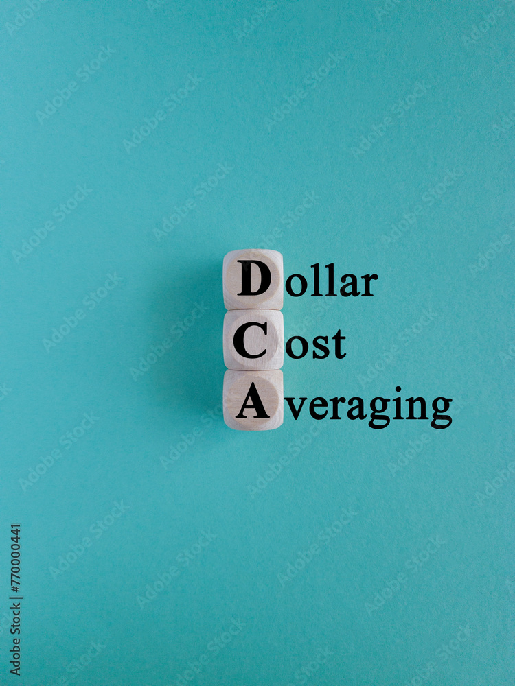 Wall mural dca (dollar cost averaging) words on a wooden cubes. blue background. saving stock or savings on a m