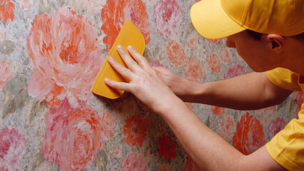 Builder smooths the wallpaper with a spatula. Repair in the house.