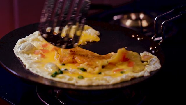 egg omlete fry by spoon on hot pan