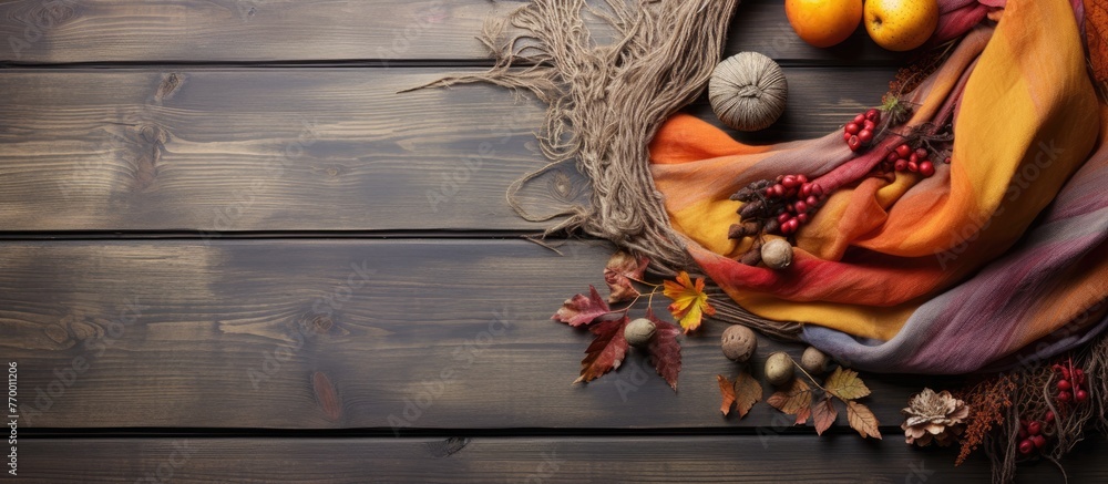 Poster a scarf and leaves are placed on a wooden table, creating a natural and artistic display. the combin