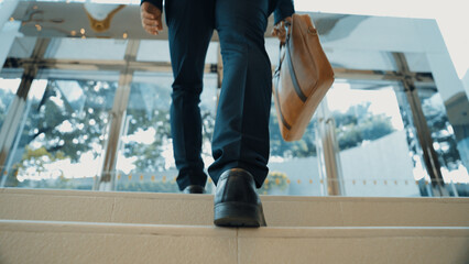 Closeup of business man leg go up the stairs. Successful man going up the stairs while explore a...