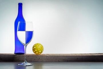 Still life Pickleball with art wine bottle and glass.