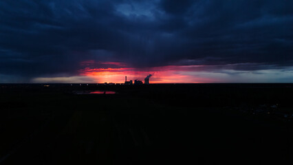 Czerwony zachód słońca nad elektrownią.