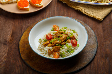 Thai chicken with rice in sauce, canap s with caviar and salad with ivy on a table