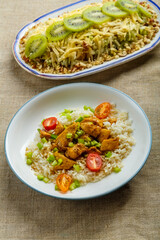 Chicken salad decorated with kiwi and nuts and Thai chicken on a plate on a linen napkin on the table