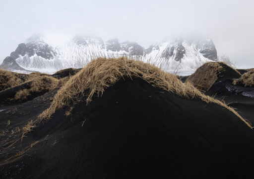 Black sand dunes with snowy mountain backdrop in Iceland