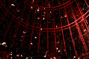 inside red big bird cage with white snow flying dust flake 