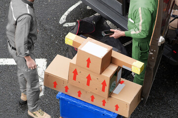 delivery courier worker with packages boxes with boxcar for delivering in city - 770022463