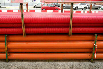 red corrugated pipes for  water or communications or sewer for install  in construction site on street city