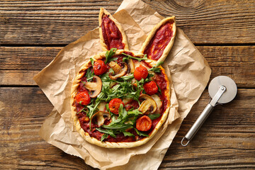 Tasty pizza and cutter on wooden background. Easter celebration