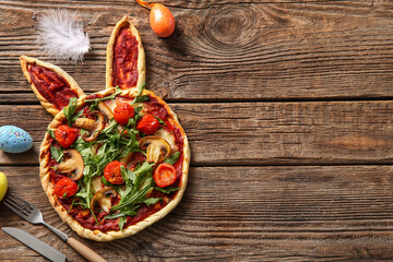 Composition with tasty pizza and eggs on wooden background. Easter celebration