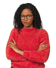 African American woman in studio setting frowning face in displeasure, keeps arms folded.