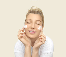woman applying serum, lotion to her face
