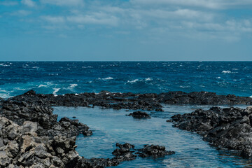 Makapuʻu Tide Pools, basalt comes from the Koʻolau volcano in eastern Oahu, Hawaii Geology. Waves hitting the rocks. 
