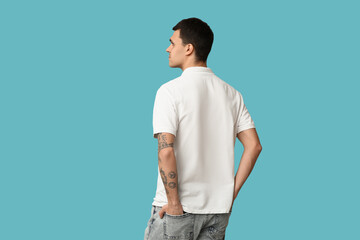 Handsome young man in stylish white t-shirt on blue background, back view