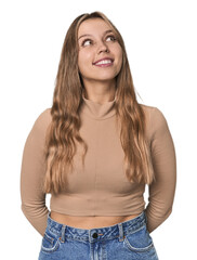 Studio portrait of a blonde Caucasian woman relaxed and happy laughing, neck stretched showing teeth.