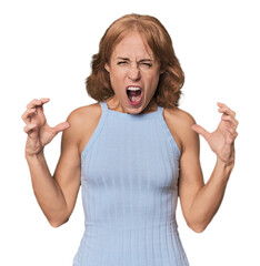 Redhead mid-aged Caucasian woman in studio screaming with rage.