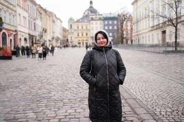 A woman standing on the city street	