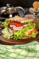 Sandwich with ham, cucumber, tomato and lettuce.