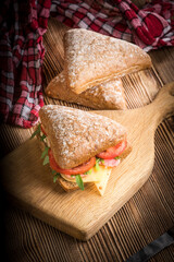 Triangular sandwich with cheese, ham and tomato.