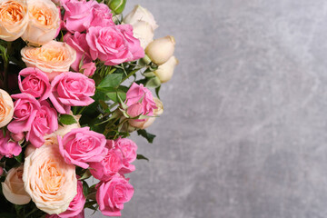 Beautiful bouquet of fresh roses on grey background.