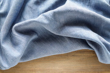 Abstract background with wavy linen fabric on wooden table.