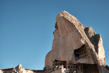 Cave dwelling carved in limestone rock formations. Fairy chimney at Cappadocia. Rock hoodoo in...