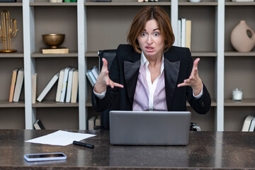 Angry female office worker standing on the table and demonstrating her irritation and dissatisfaction of work	 - obrazy, fototapety, plakaty