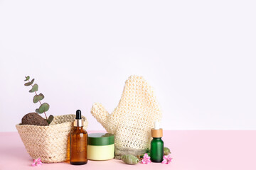 Composition with spa accessories and cosmetics on color table against white background