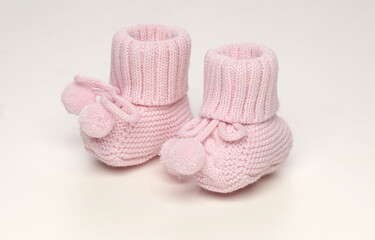 Fototapeta na wymiar baby booties, for newborns, the first shoes with delicate feet on a light background