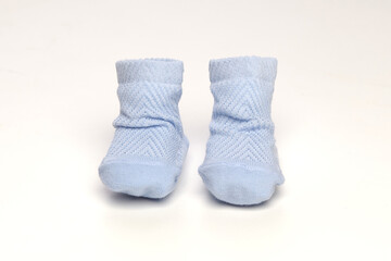 baby socks, for newborns, the first shoes with delicate feet on a light background