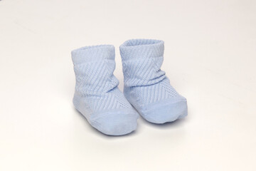 baby socks, for newborns, the first shoes with delicate feet on a light background