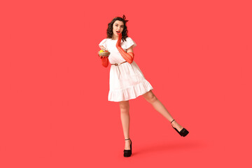 Beautiful pin-up woman in laced gloves holding Easter eggs on red background
