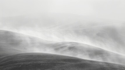 Fototapeta na wymiar A monochrome image of a rolling landscape featuring hilly terrain in the background and foggy foreground