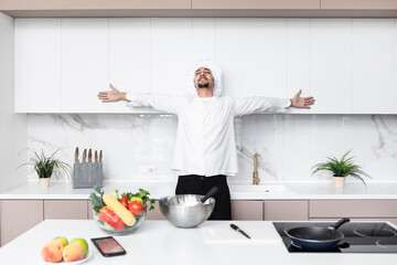 Young handsome male chef in cooking in the kitchen	