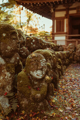 Stone Jizo statues line an autumn trail in quiet remembrance in Kyoto.