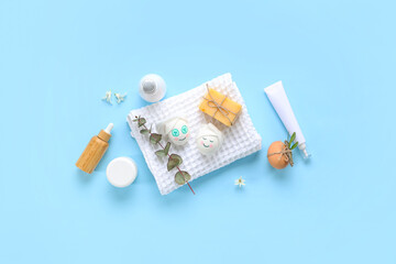 Composition with spa accessories and funny Easter eggs on color background