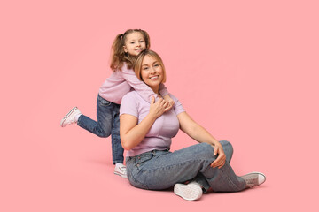 Mother playing with her daughter on pink background. Mother's Day