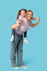 Little girl playing with her mother on blue background