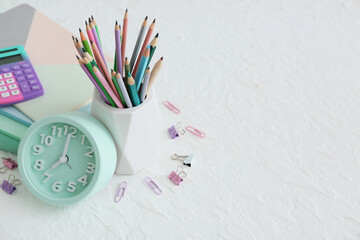 Alarm clock and stationery on white background