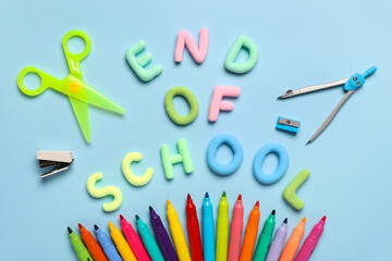 Text END OF SCHOOL, scissors and colorful felt-tip pens on blue background. Top view