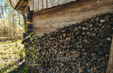 Chopped firewood pile stacked under the roof. Woodpile board wall. Wood. Old dry pine wooden heap....