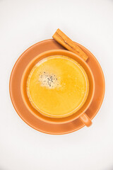 Xícara de café preto com espuma dourada, pires e xicara em terracota, bege, marrom, terra,  rama...