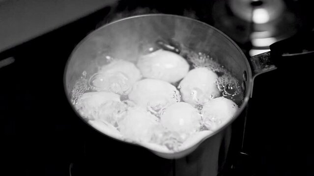 top view of boiling chicken eggs in metal pot with hot water 