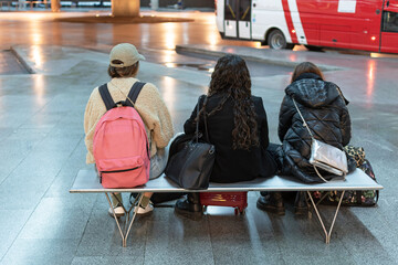 Friends with suitcases waiting at the bus station