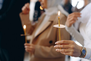 hand with church candle - obrazy, fototapety, plakaty